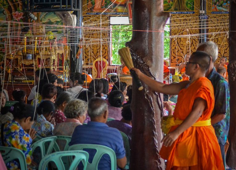 Monk Splashing Water at Temple for Songkran Festival in Thailand